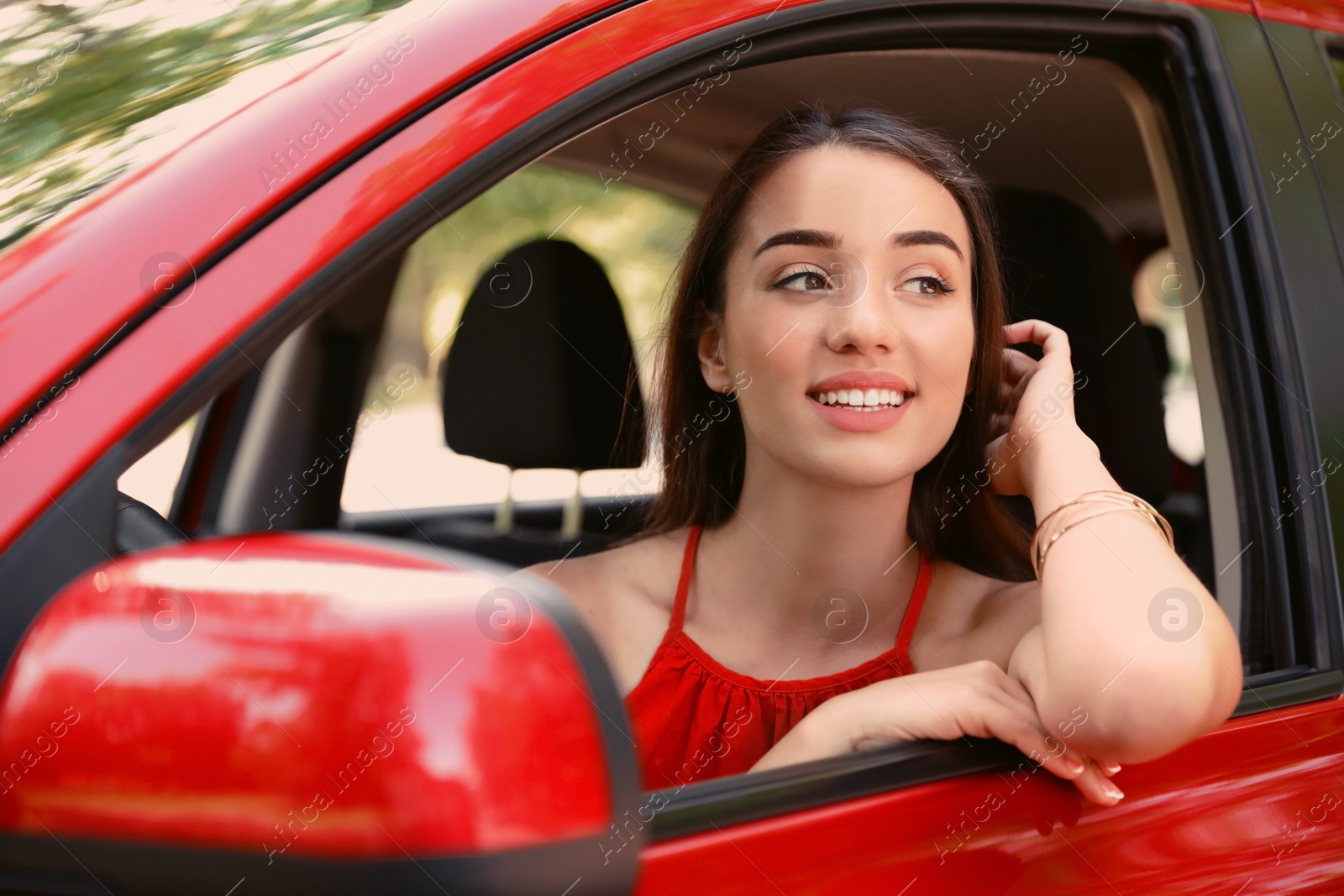 Photo of Happy young beautiful woman in modern car