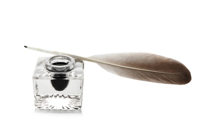 Photo of Feather pen and inkwell on white background