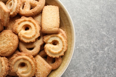 Photo of Bowl with Danish butter cookies on grey background, top view. Space for text