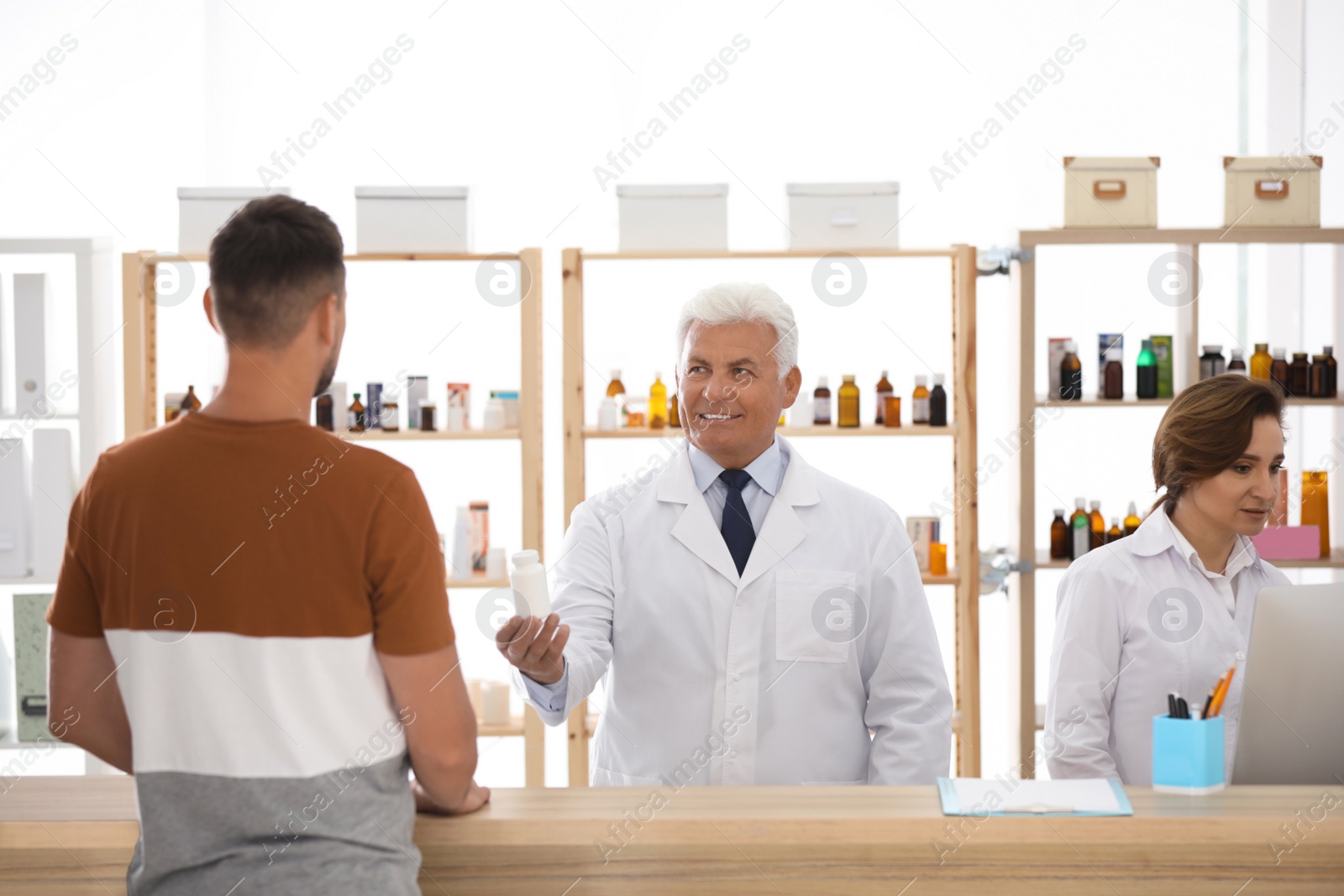 Photo of Pharmacist giving medicine to customer in drugstore