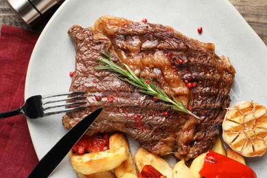 Photo of Delicious grilled beef steak and vegetables served on table, top view