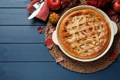 Photo of Delicious homemade apple pie and autumn decor on blue wooden table, flat lay. Space for text