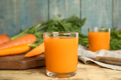 Photo of Freshly made carrot juice on wooden table