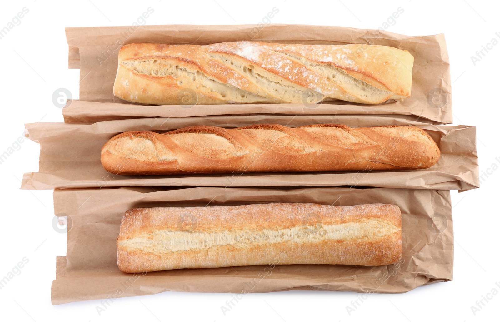 Photo of Different tasty baguettes and packages on white background, top view. Fresh bread