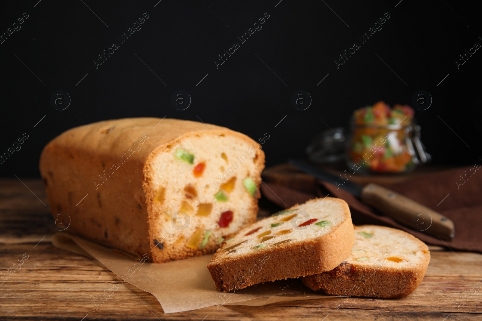 Photo of Delicious cake with candied fruits on wooden table