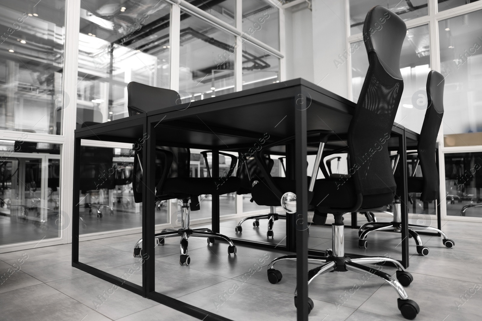 Photo of Comfortable office chairs and tables in meeting room, low angle view