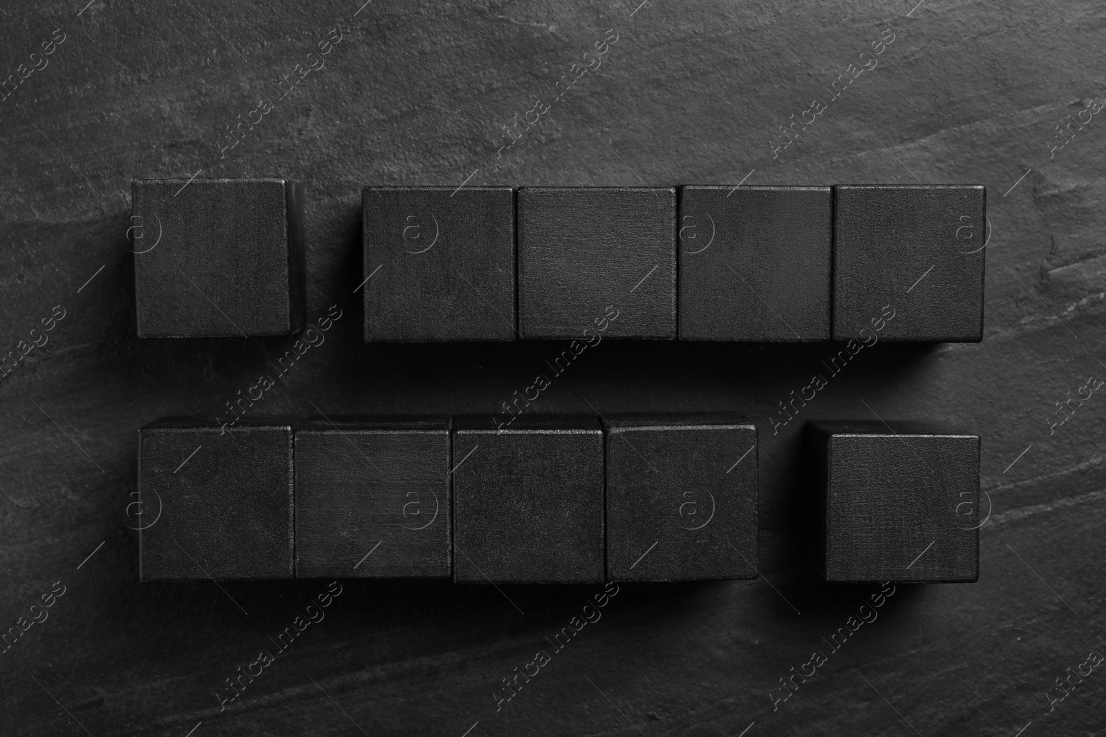 Photo of Flat lay composition with cubes on black slate background. Pareto principle concept