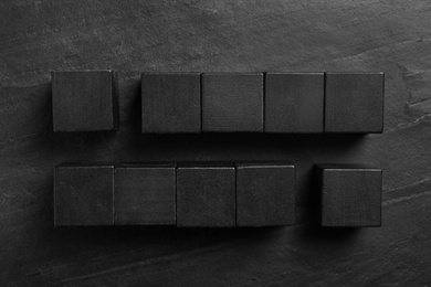 Photo of Flat lay composition with cubes on black slate background. Pareto principle concept