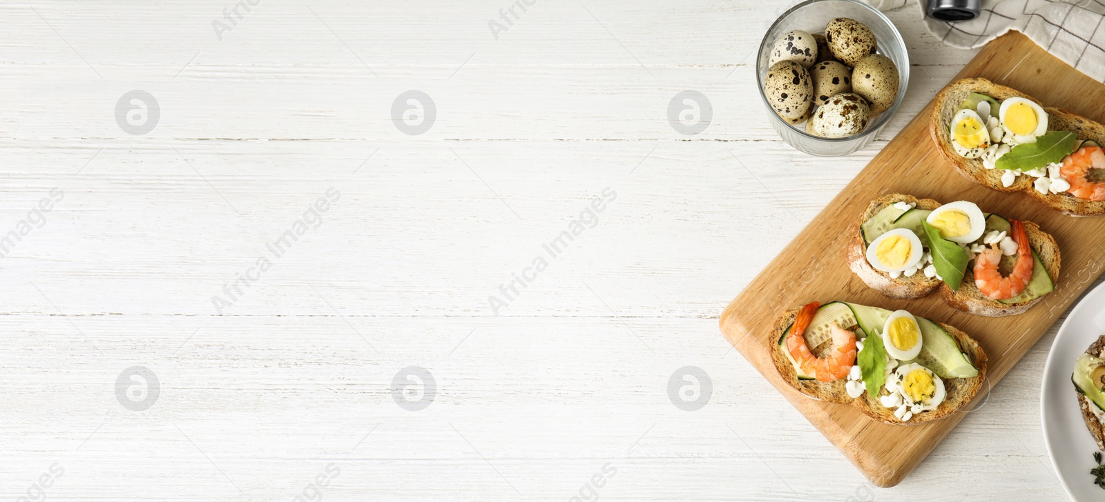 Image of Flat lay composition with delicious bruschettas on white wooden table, space for text. Banner design 