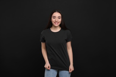 Photo of Woman wearing black t-shirt on dark background