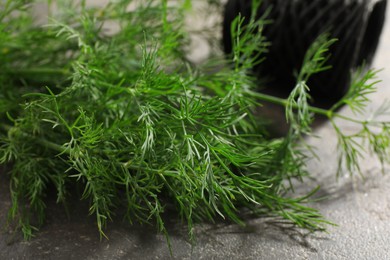 Photo of Fresh dill on grey textured table, closeup