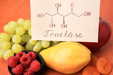 Photo of Card with word Fructose, delicious ripe fruits, raspberries and dried apricots on table, closeup