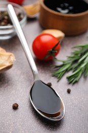 Photo of Organic balsamic vinegar and cooking ingredients on grey table, closeup