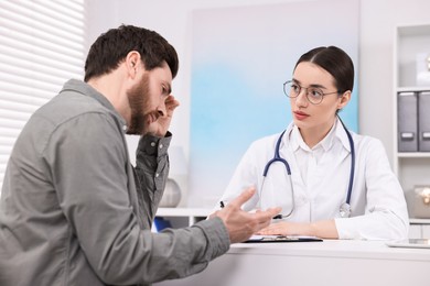 Photo of Doctor consulting patient during appointment in clinic