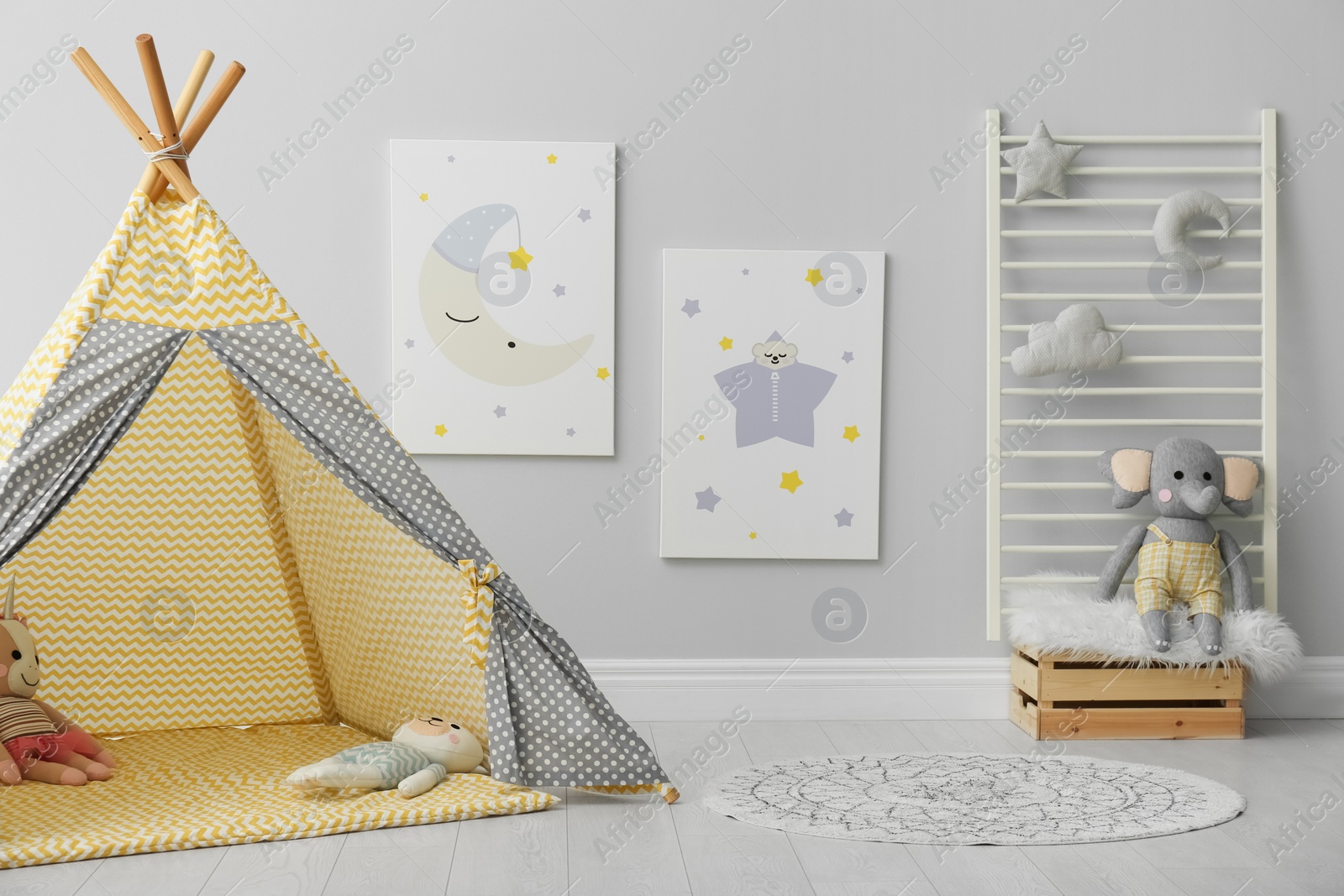 Photo of Stylish child's room interior with adorable paintings and play tent