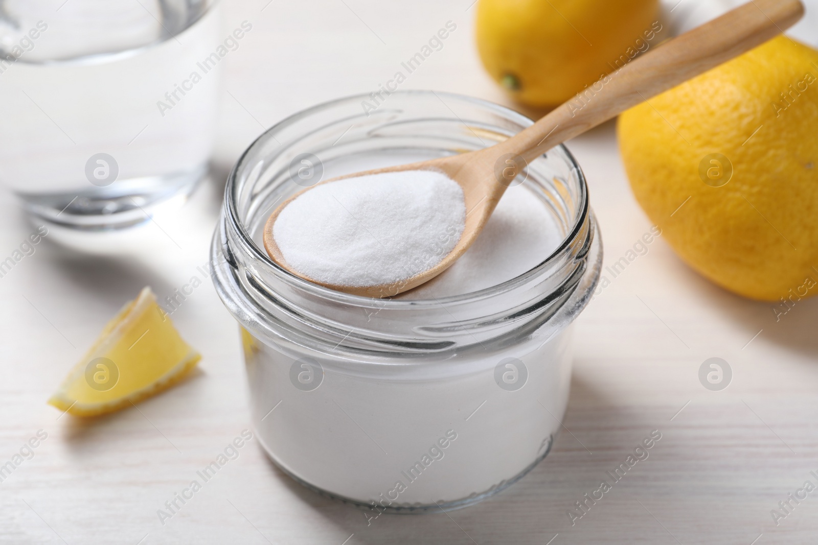 Photo of Baking soda, vinegar and lemons on white wooden table, closeup
