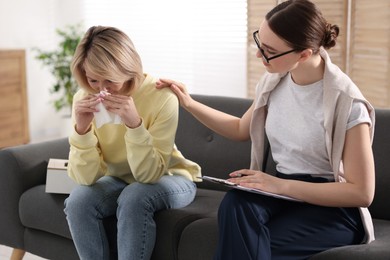Photo of Professional psychotherapist working with on sofa patient in office