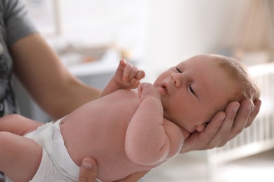 Father holding his little baby in bedroom