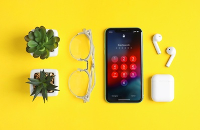 Photo of MYKOLAIV, UKRAINE - JULY 10, 2020: Flat lay composition with Iphone 11 and AirPods on yellow background, flat lay