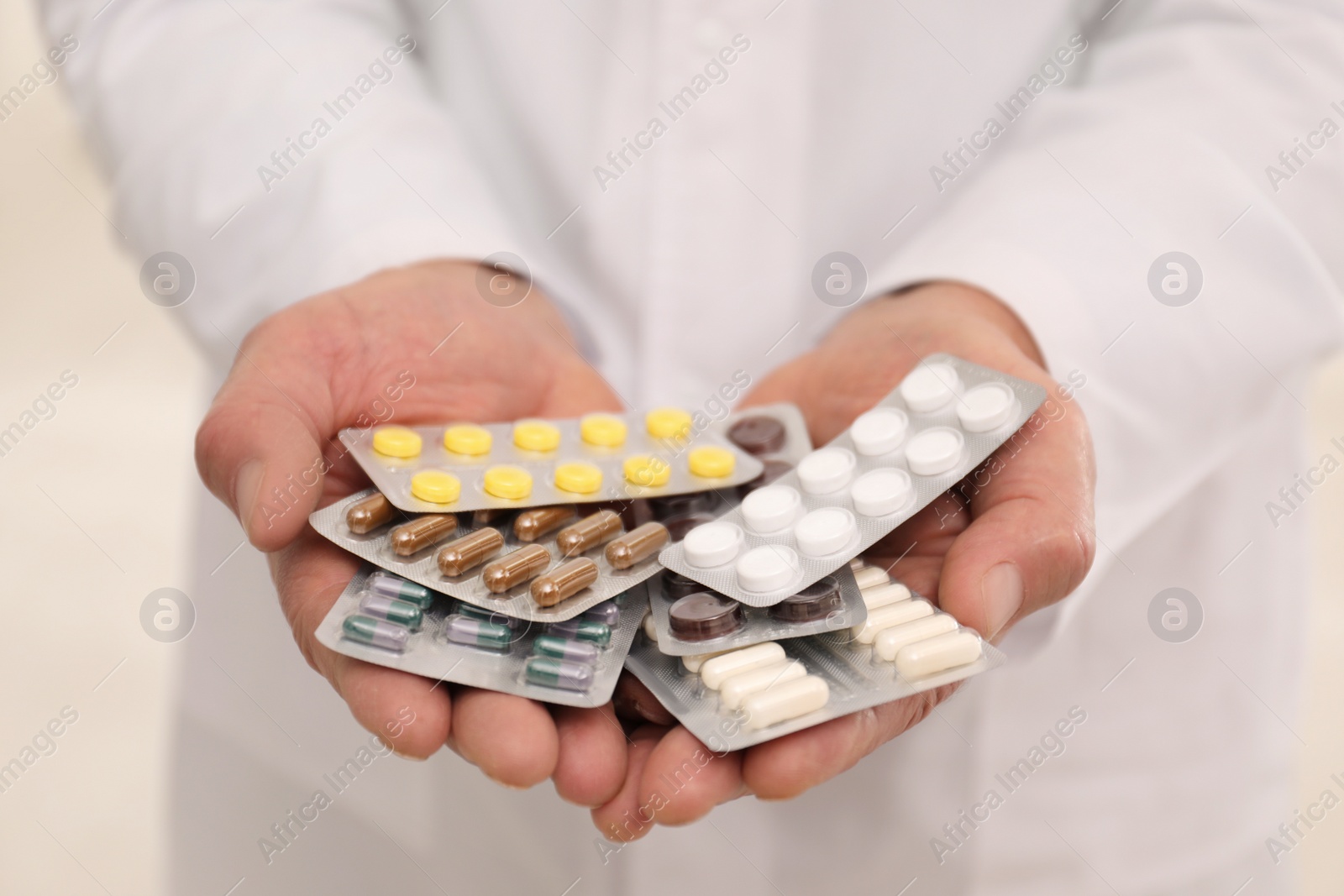 Photo of Senior pharmacist with handful of pills, closeup