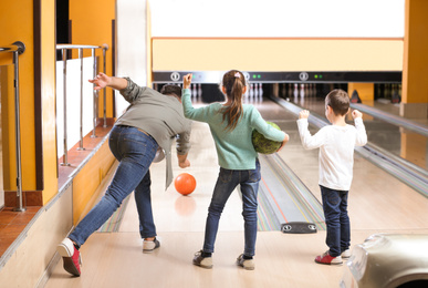 Photo of Happy family spending time together in bowling club