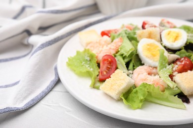 Delicious Caesar salad with shrimps on white table, closeup. Space for text