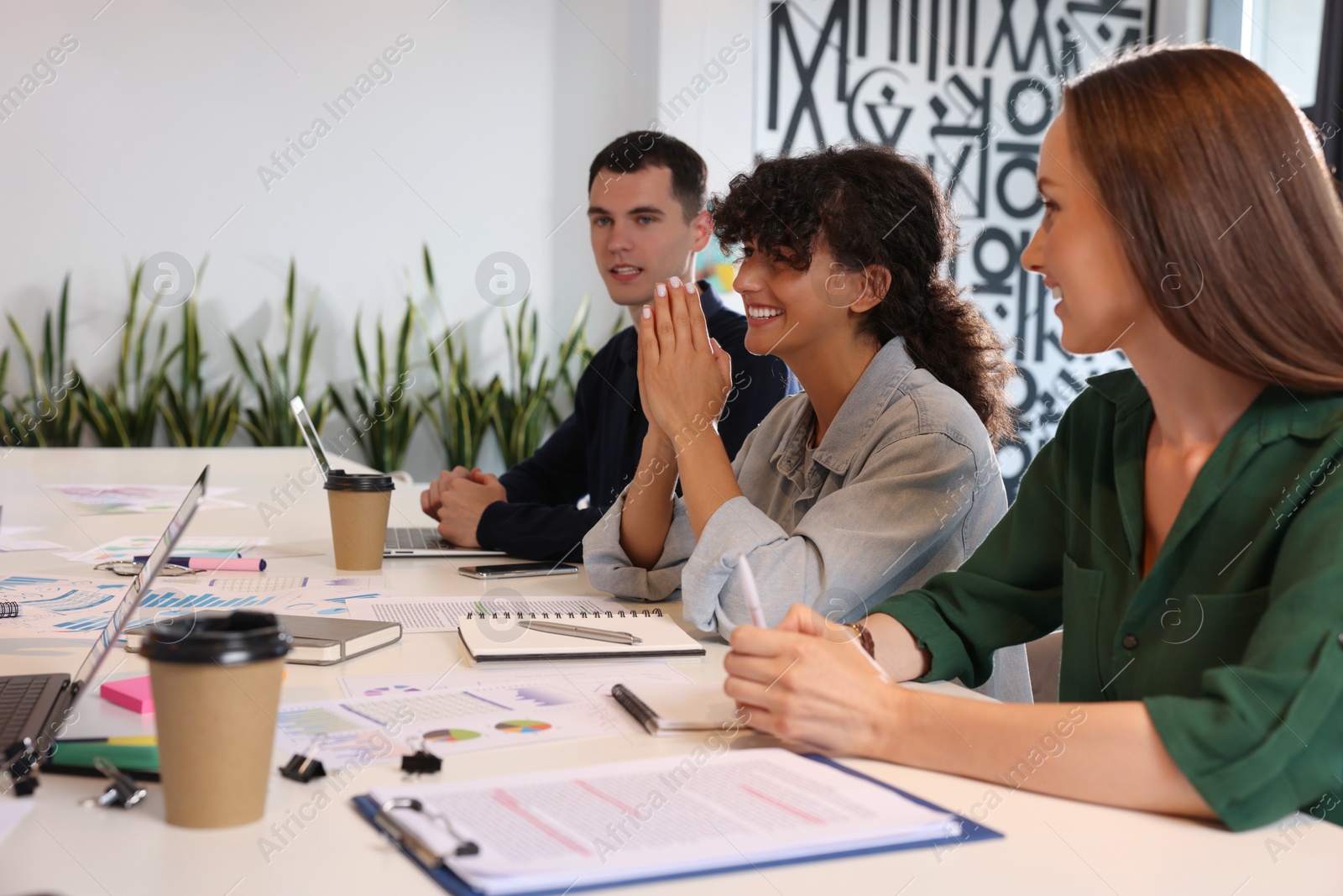 Photo of Team of employees working together at table in office. Startup project