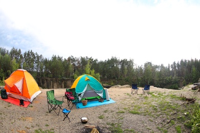 Camping tents and accessories in wilderness on summer day