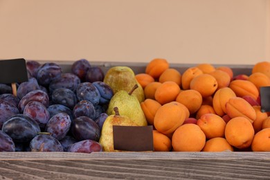 Photo of Fresh ripe fruits in wooden crate at market, closeup