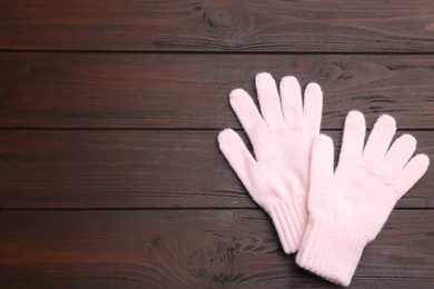 Photo of Stylish pink gloves on wooden background, flat lay. Space for text