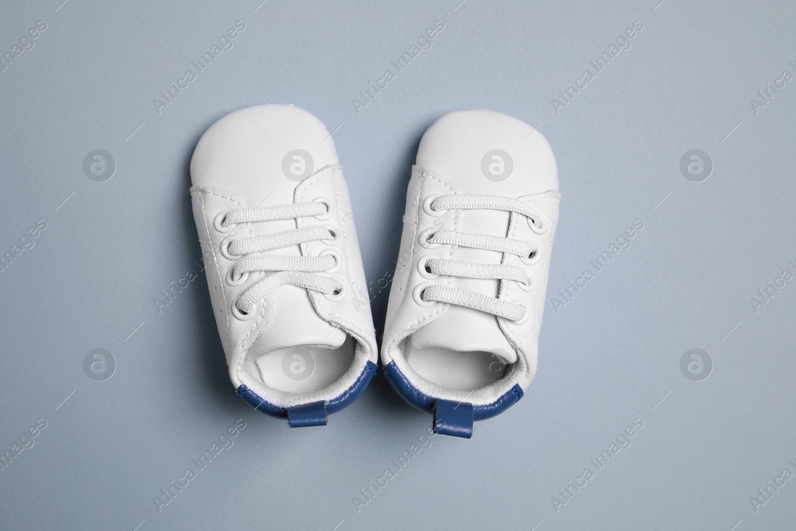 Photo of Cute baby shoes on grey background, flat lay