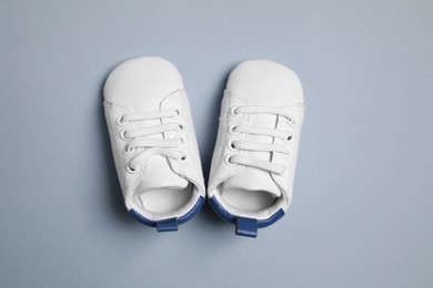 Cute baby shoes on grey background, flat lay