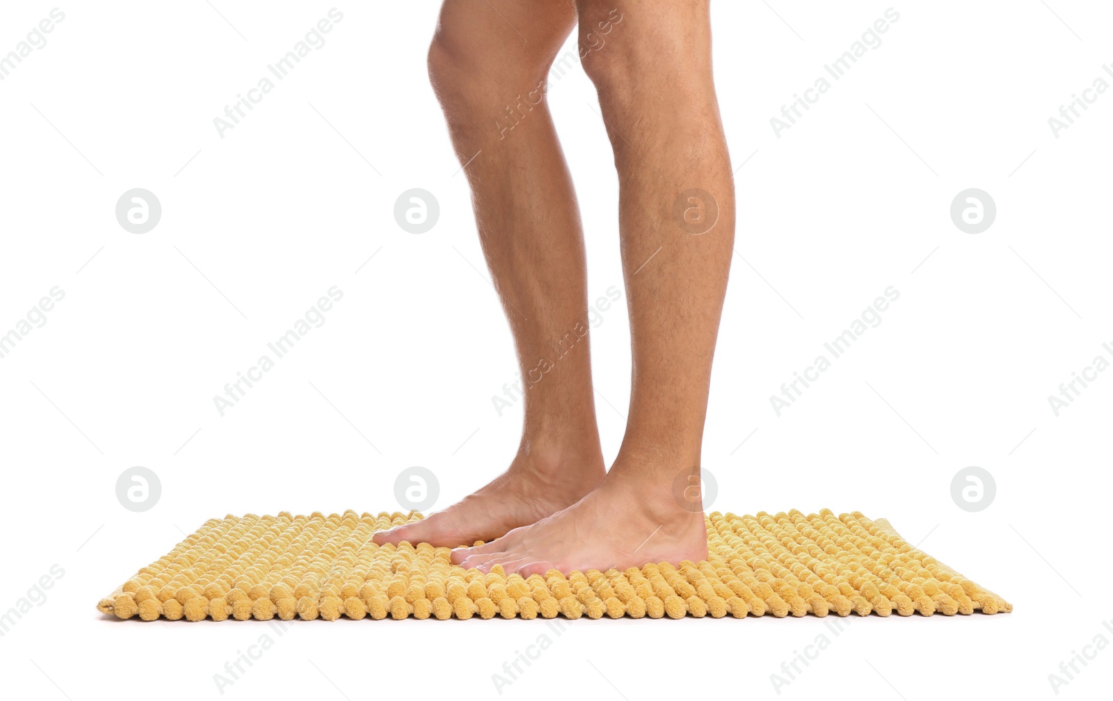 Photo of Man standing on soft yellow bath mat against white background, closeup