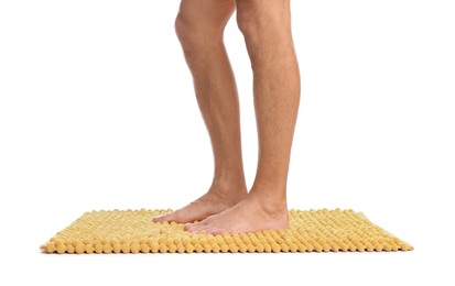 Man standing on soft yellow bath mat against white background, closeup