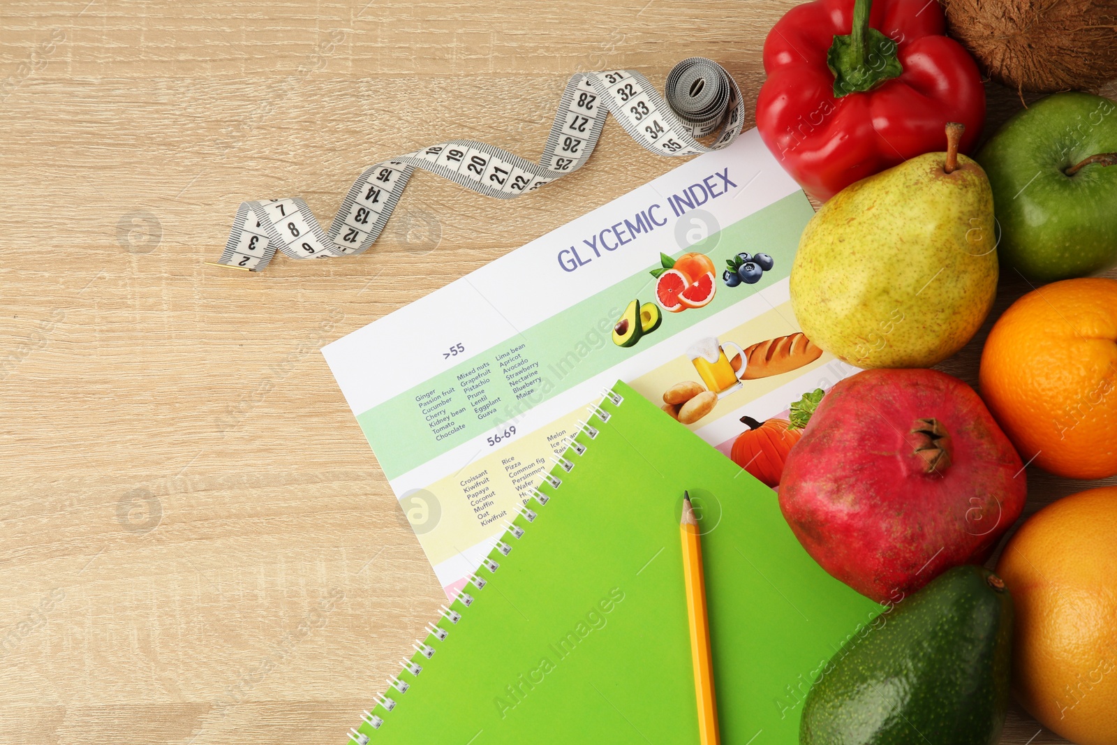 Photo of Flat lay composition with products and Glycemic index chart on wooden table, space for text