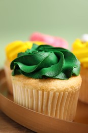 Delicious cupcakes with bright cream on table, closeup