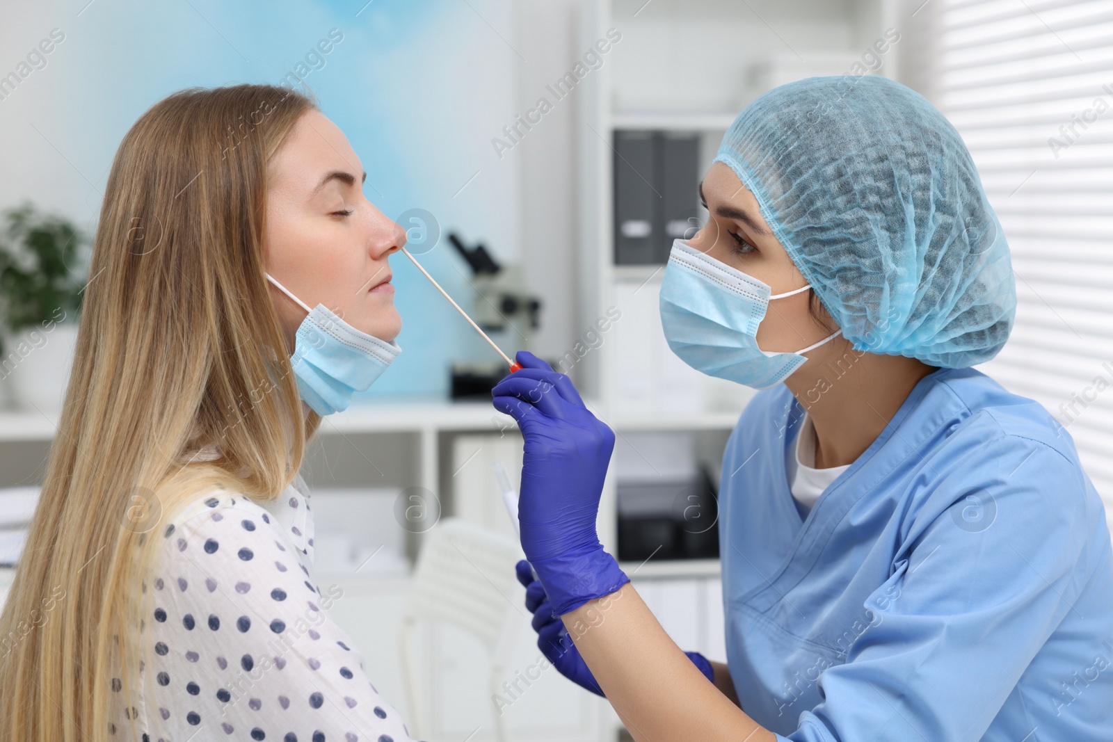 Photo of Laboratory testing. Doctor taking sample from patient's nose with cotton swab in hospital