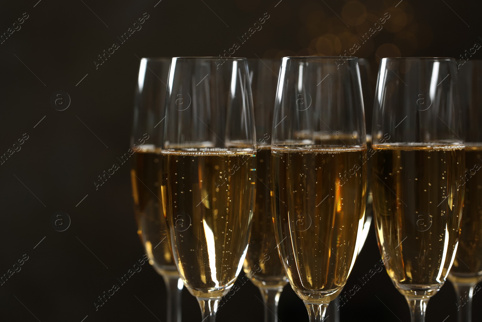 Photo of Glasses of champagne on dark background, closeup