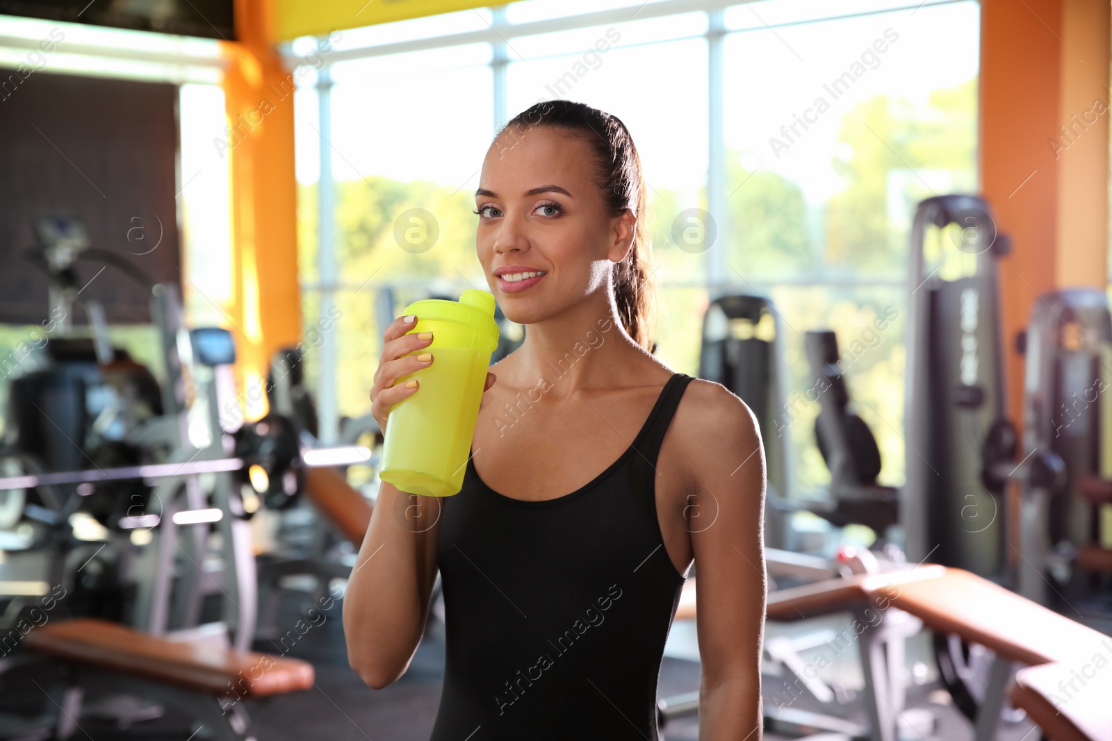 Photo of Portrait of athletic woman with protein shake in gym