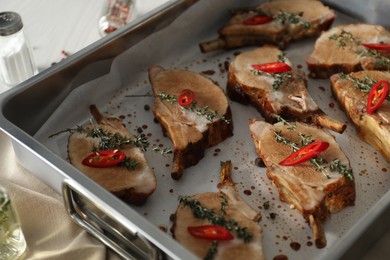 Photo of Delicious roasted ribs in baking tray, closeup