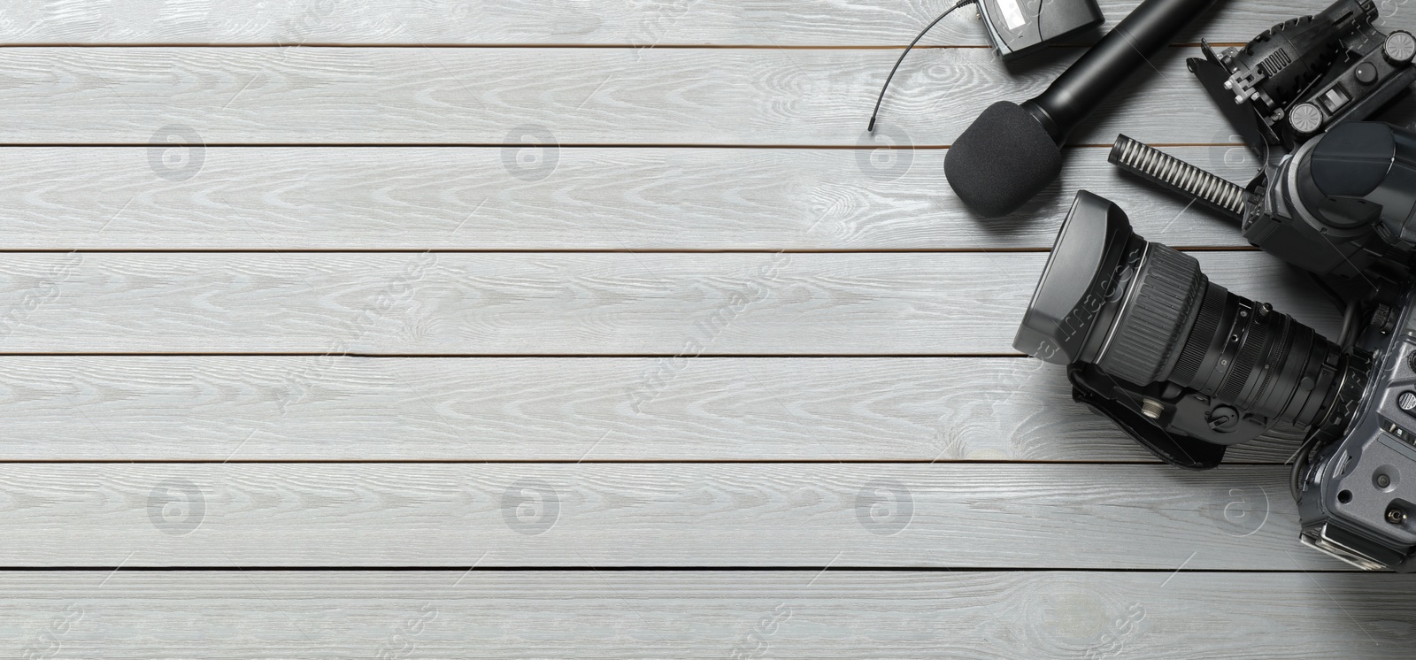 Photo of Flat lay composition with camera and video production equipment on grey wooden background. Space for text