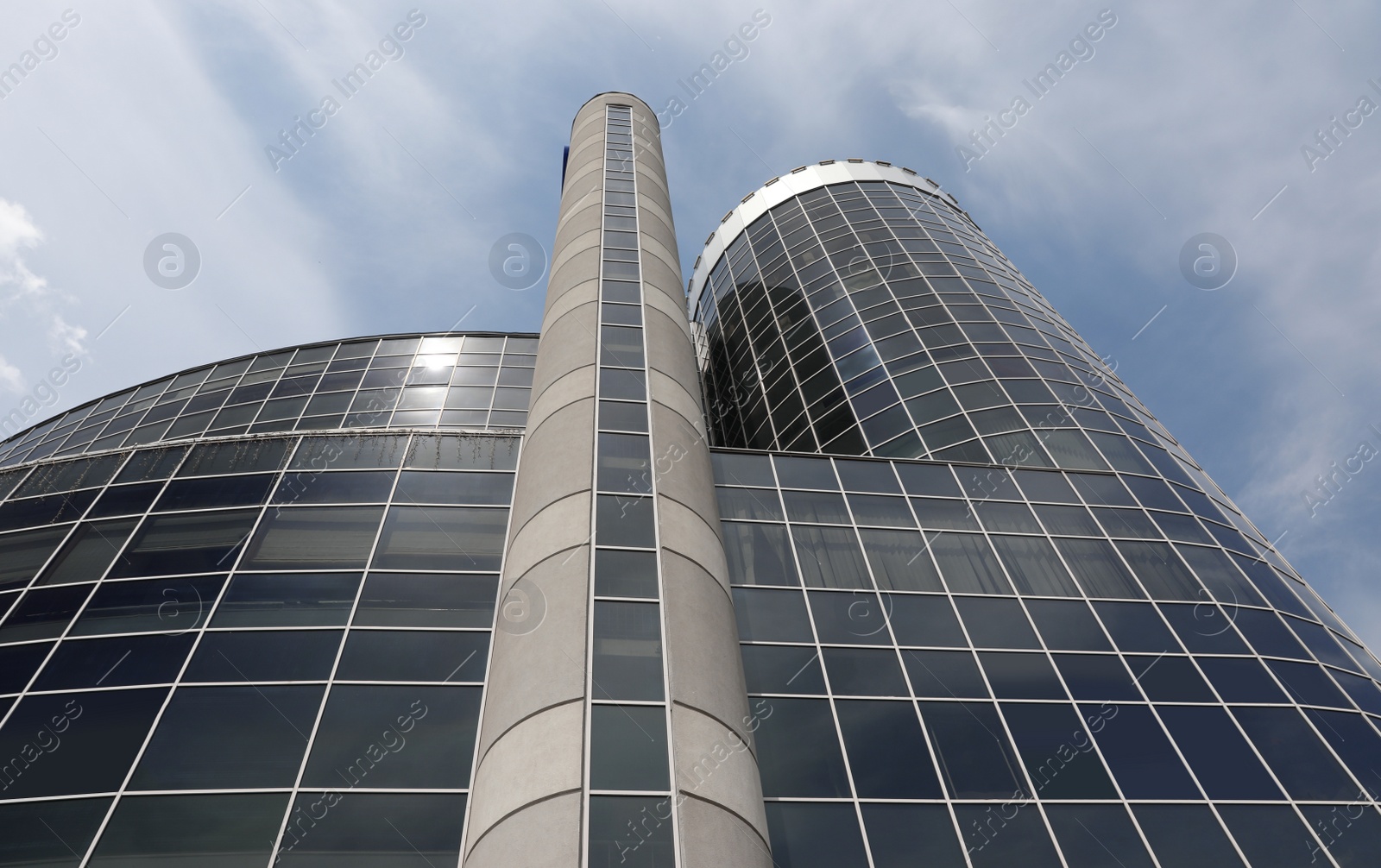 Photo of Modern building with tinted windows against sky, low angle view. Urban architecture