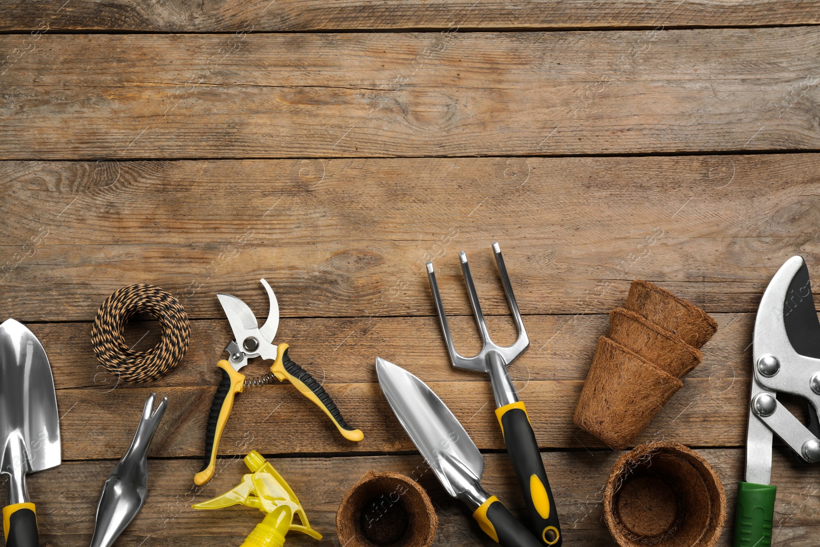 Photo of Flat lay composition with gardening tools on wooden background, space for text