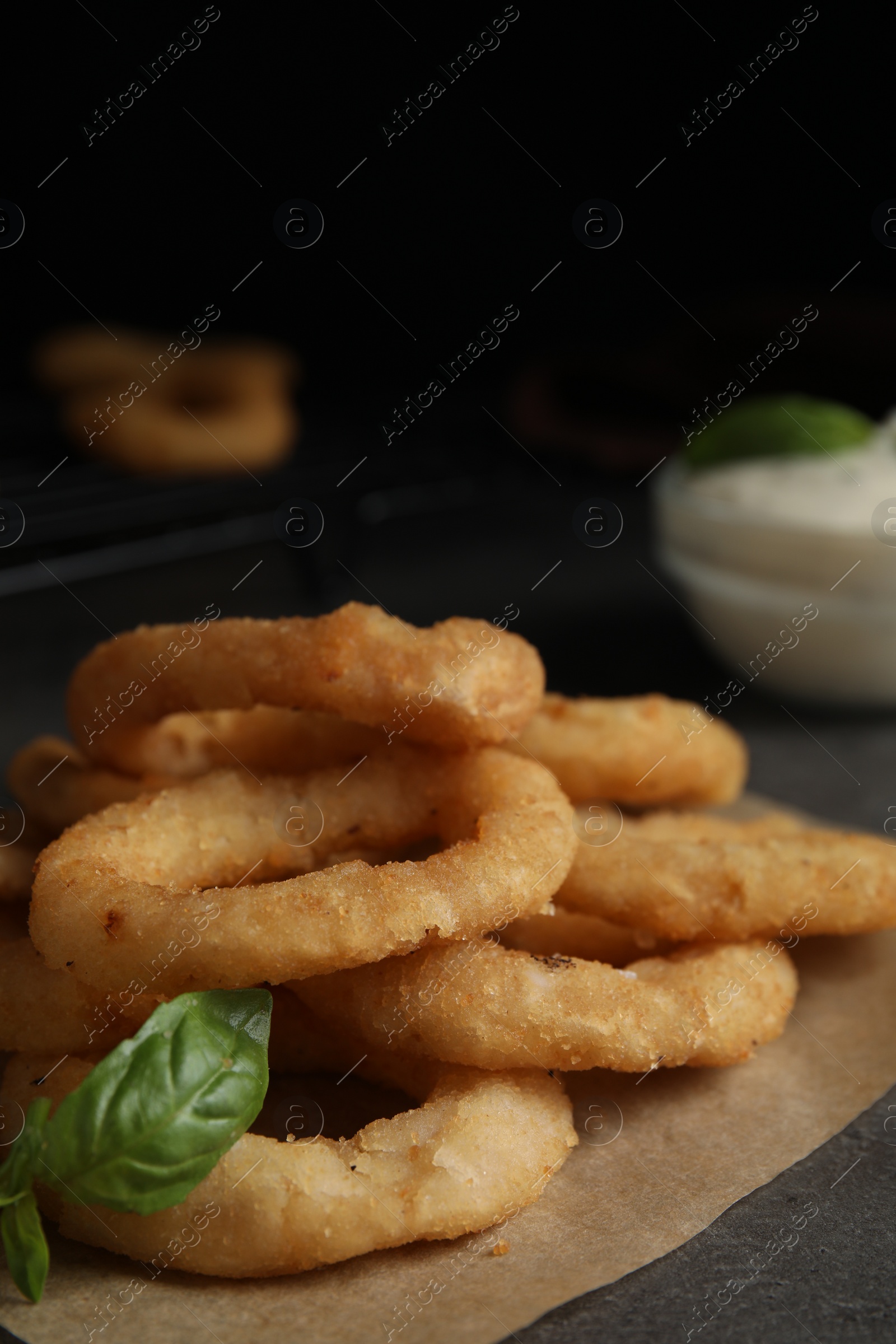 Photo of Fried onion rings served on grey table