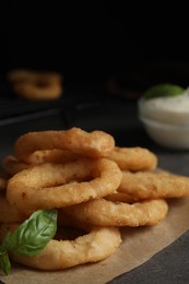 Photo of Fried onion rings served on grey table