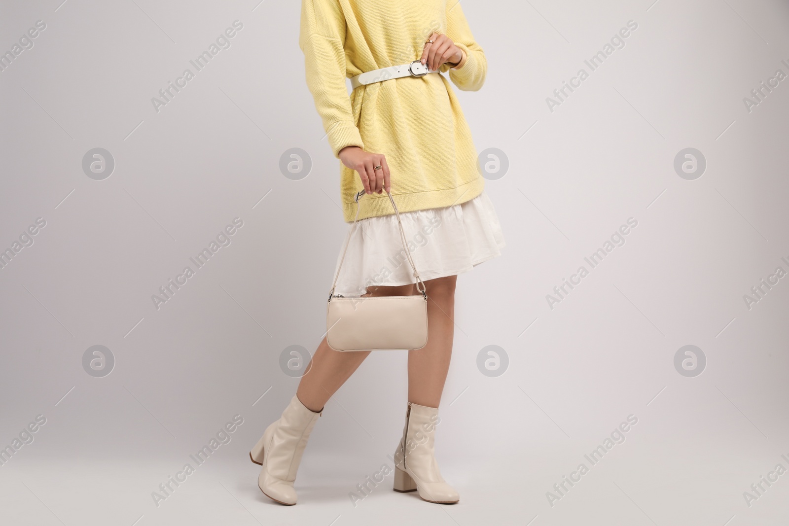 Photo of Fashionable woman with stylish bag on light background, closeup