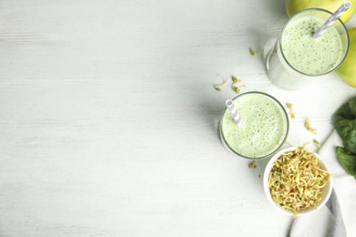 Photo of Flat lay composition with green buckwheat smoothie on white wooden table, space for text