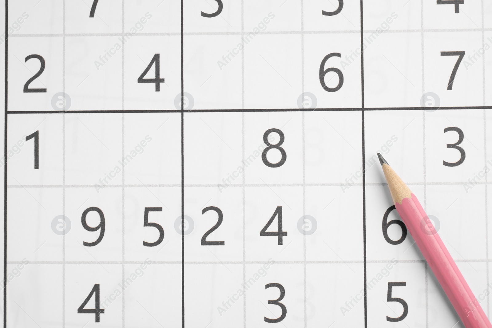 Photo of Sudoku and pencil as background, top view