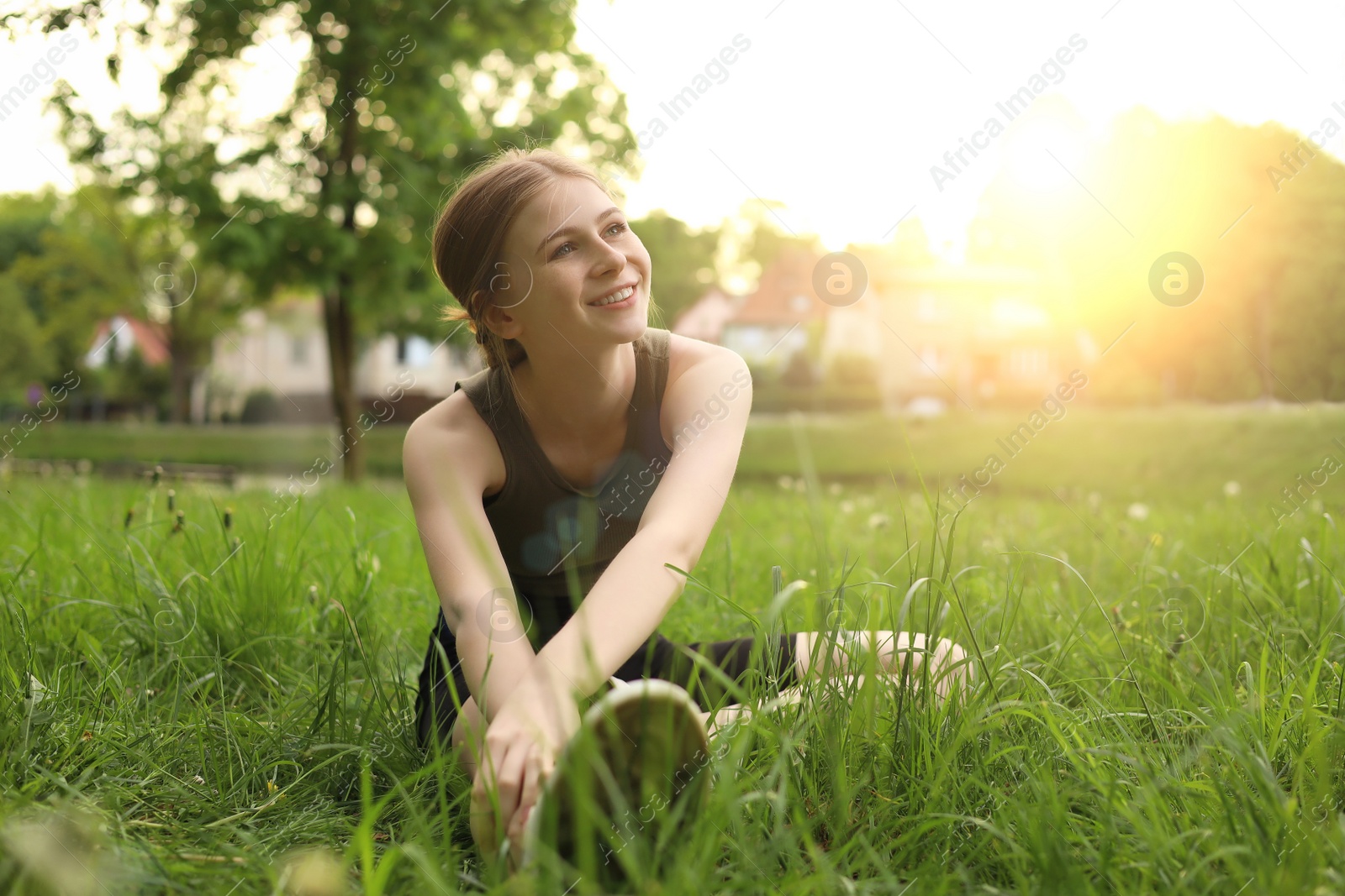 Photo of Teenage girl doing morning exercise on green grass in park