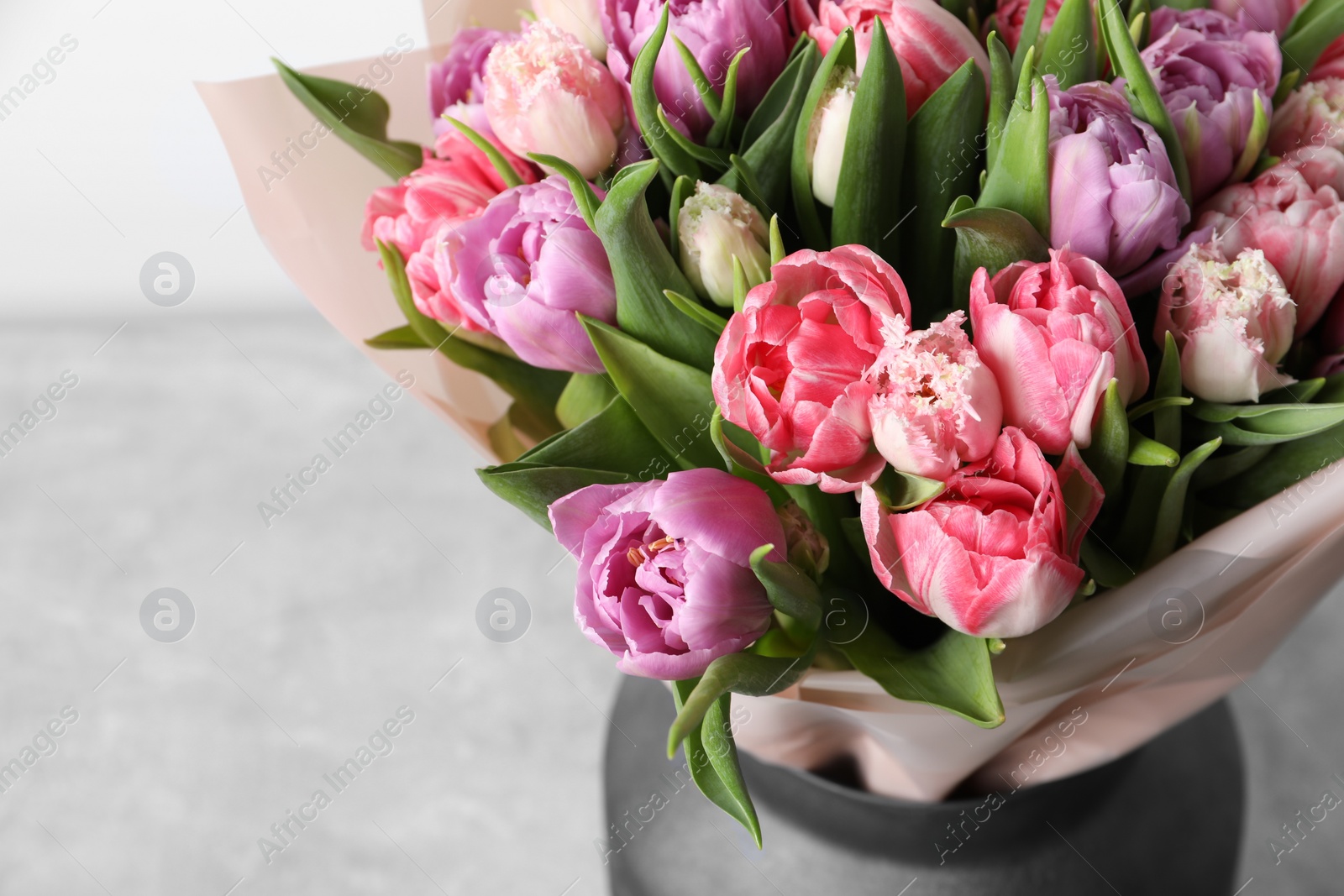 Photo of Vase with bouquet of beautiful tulips on table, closeup. Space for text